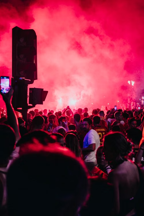 Vibrant red smoke flare concert crowd